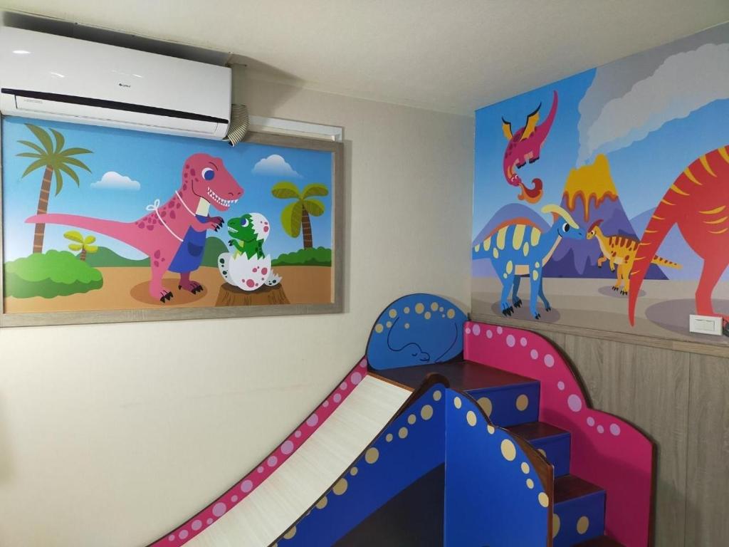 a childs room with dinosaurs on the wall at Happy Castle Cottage in Hualien City