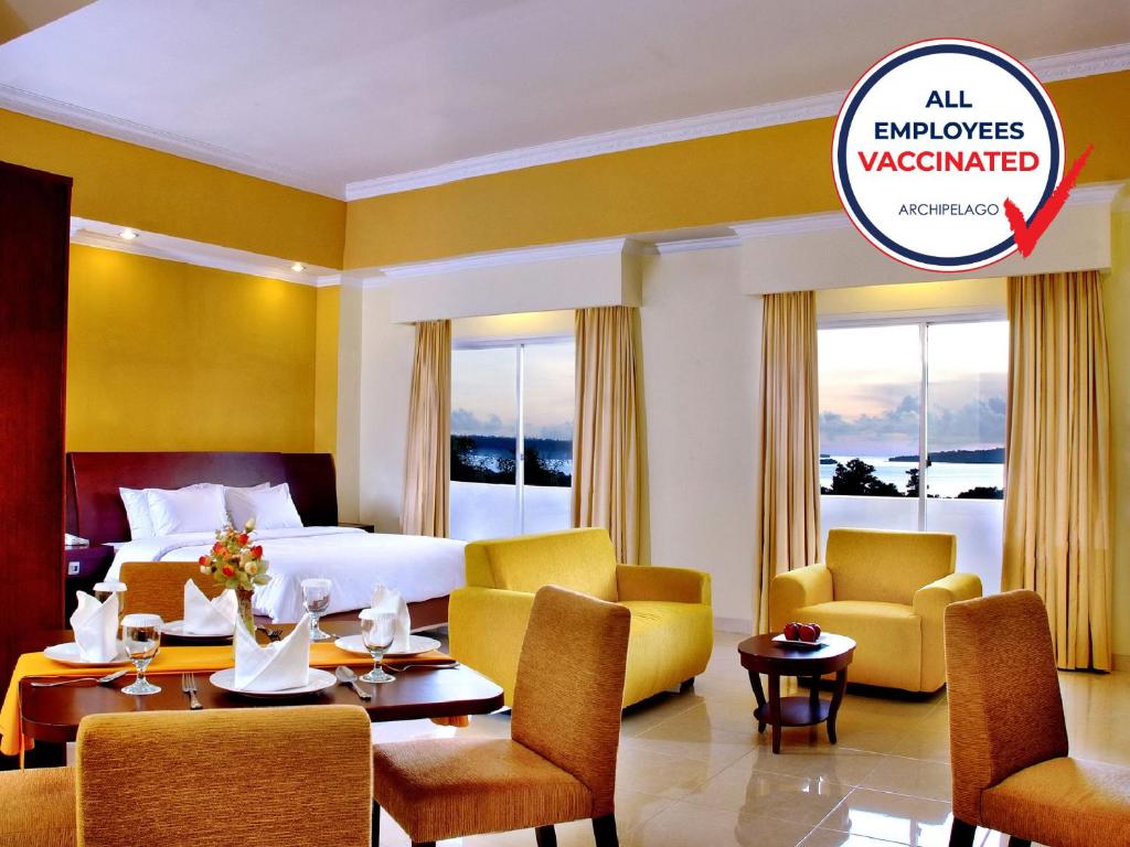 ASTON Niu Manokwari Hotel & Conference Center في مانوكواري: غرفة بالفندق سرير وكراسي وطاولة