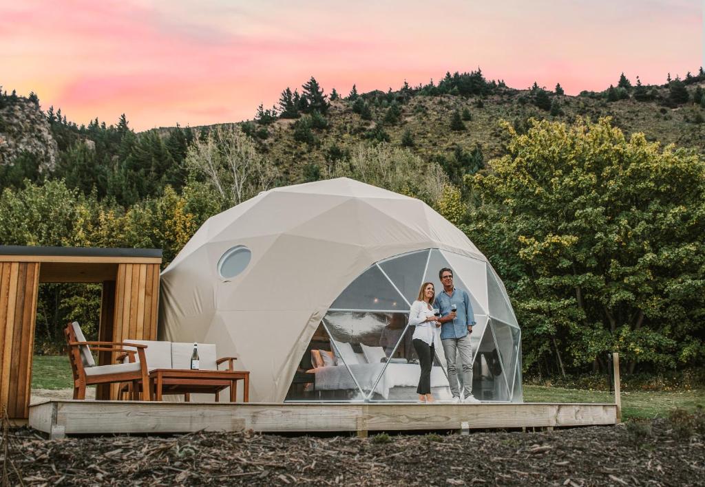 a man and a woman standing in a tent at Cross Hill Glamping in Lake Hawea