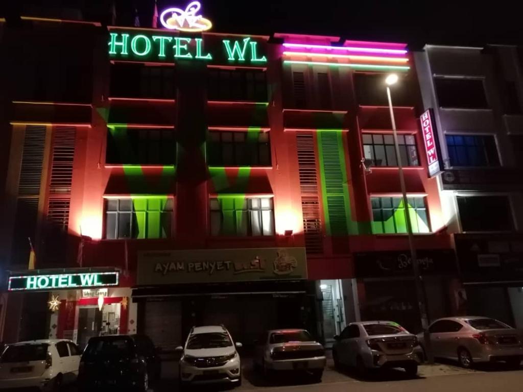 a hotel building with cars parked in front of it at WL HOTEL in Kampung Baharu Sungai Buluh