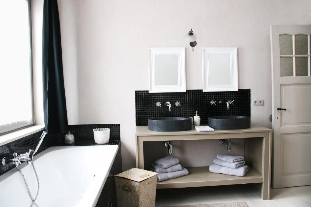 ein Badezimmer mit 2 Waschbecken und einer Badewanne in der Unterkunft ieperlee 23 Holiday Home in Ypern