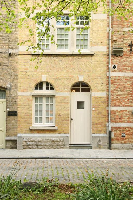 a brick building with a white door and two windows at ieperlee 23 Holiday Home in Ieper