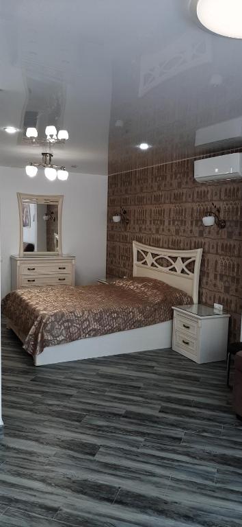 1 dormitorio con 1 cama grande y espejo en Meridian Apartments, en Sochi