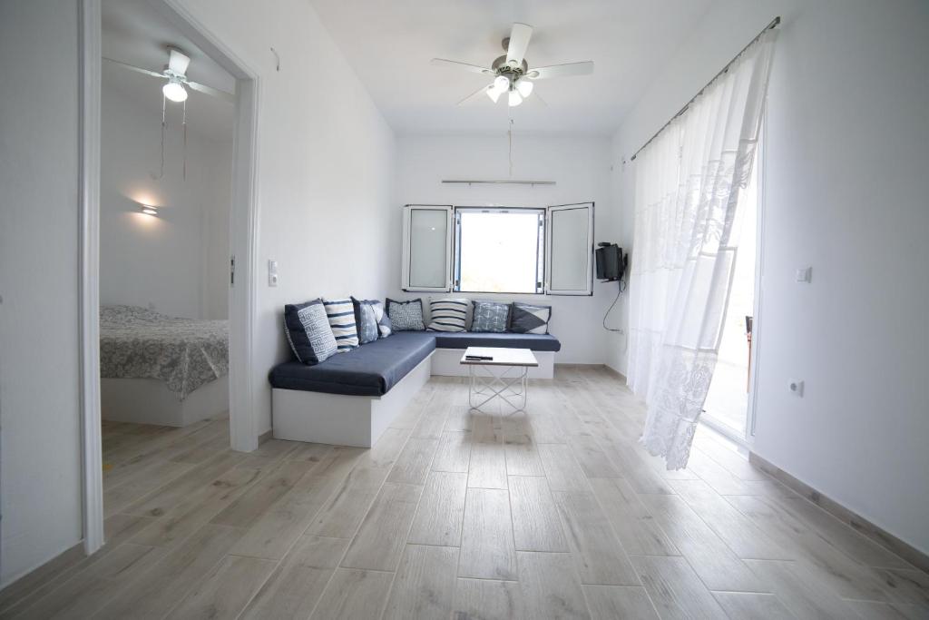 Despinas house Kythnos في كيثنوس: غرفة معيشة مع أريكة زرقاء ونافذة