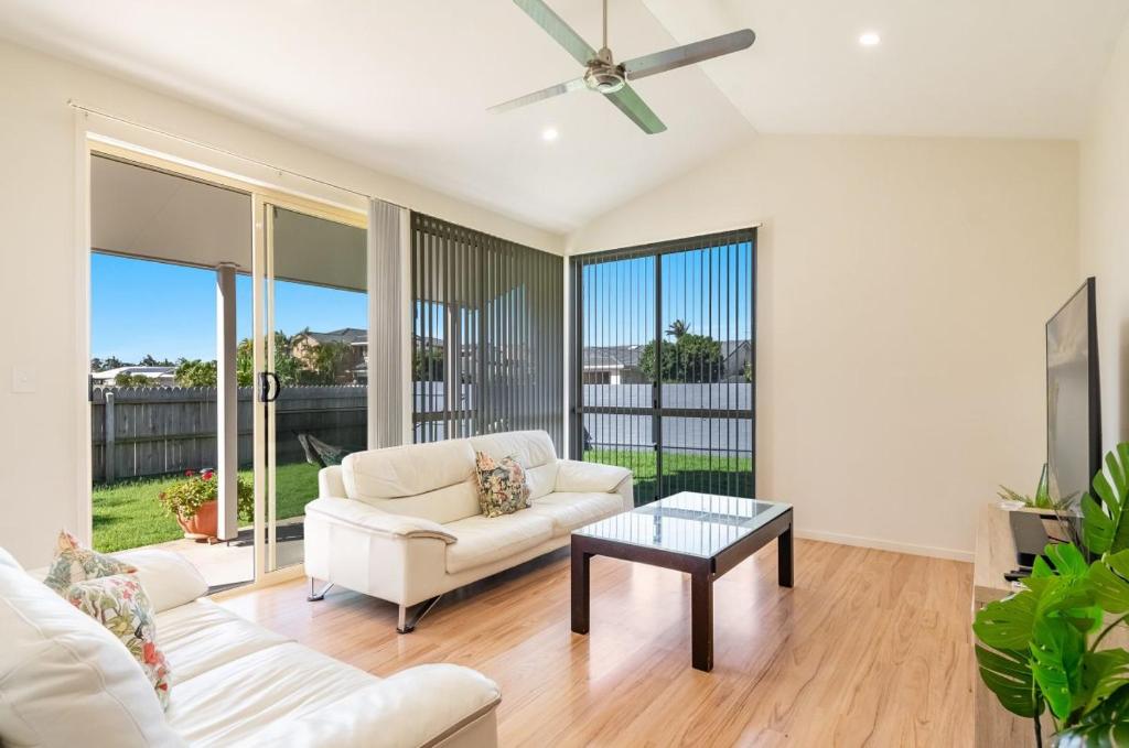 a living room with a white couch and a table at A Wave From It All - Lennox Head in Lennox Head
