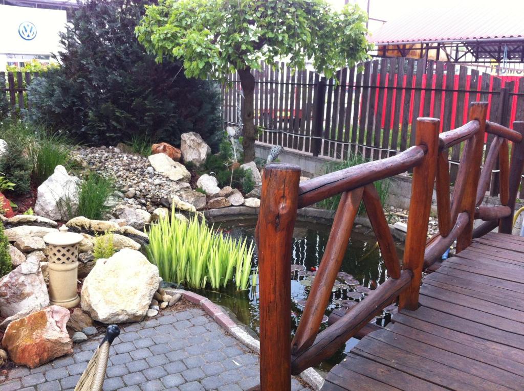 a wooden bridge over a pond in a garden at Sarokhaz Panzio in Vecsés