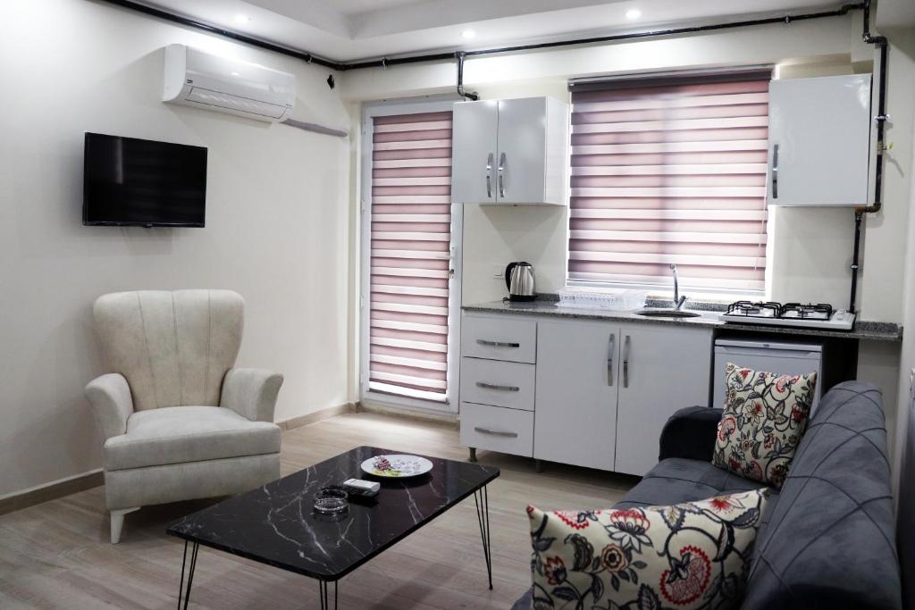 een woonkamer met een bank en een tafel en een keuken bij Royal Suite in Pamukkale