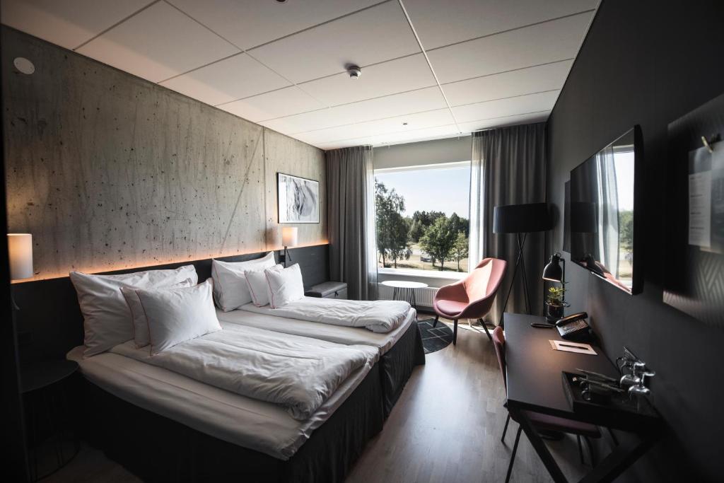 ein Hotelzimmer mit einem Bett und einem Schreibtisch in der Unterkunft Frösö Park Hotel in Östersund