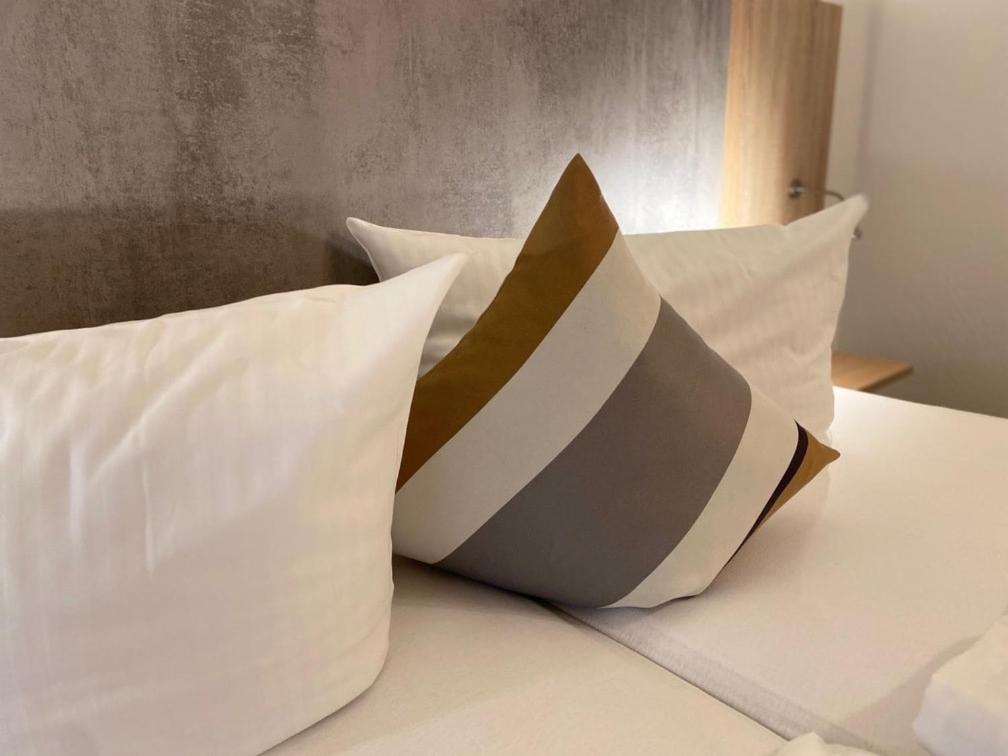 a pile of pillows sitting on top of a bed at Hotel Gloria in Alsdorf