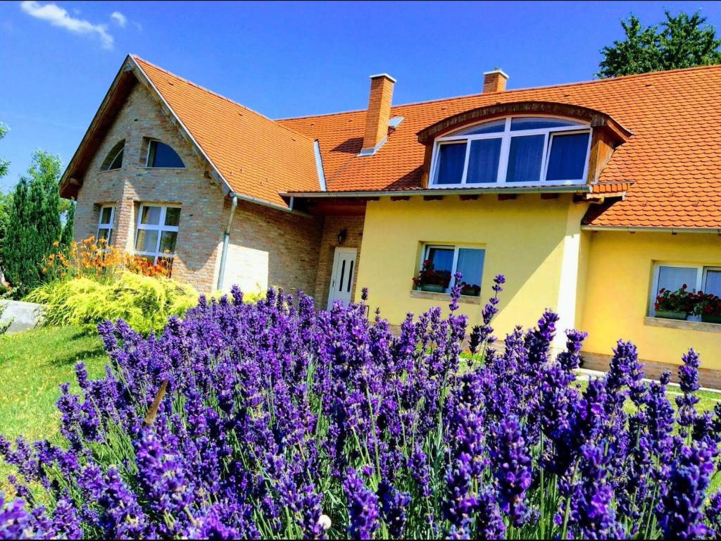 a house with purple flowers in front of it at Apartments for Rent near Budapest in Etyek