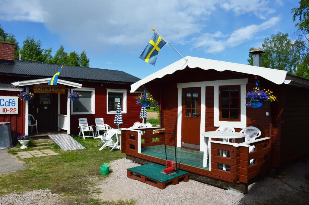 een kleine hut met een vlag op de veranda bij Stuga vid Hedenäsets stencafé in Hedenäset