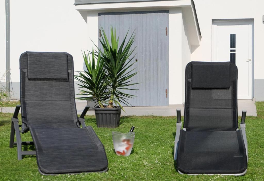 dos sillas sentadas en el césped en un patio en CAMPANELL - Das Ferienhaus im Blaufränkischland, en Deutschkreutz