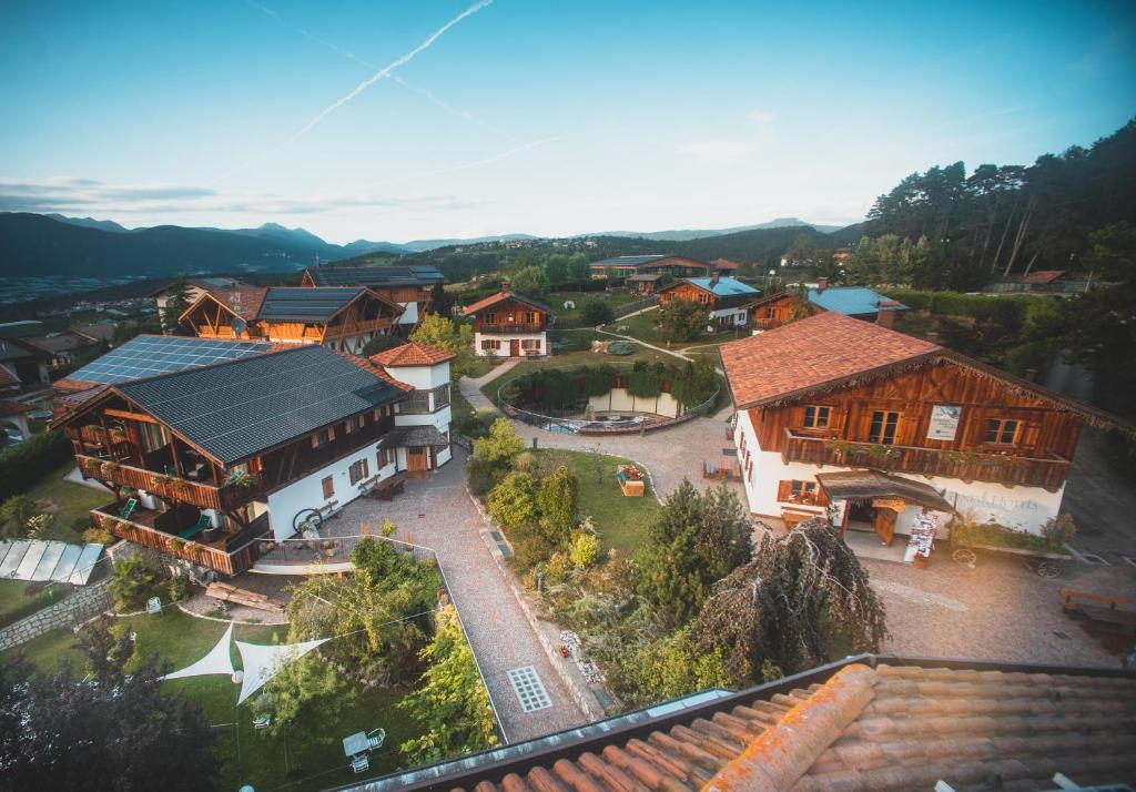 z góry widok na małą wioskę z domami w obiekcie Pineta Natural Chalet w mieście Coredo