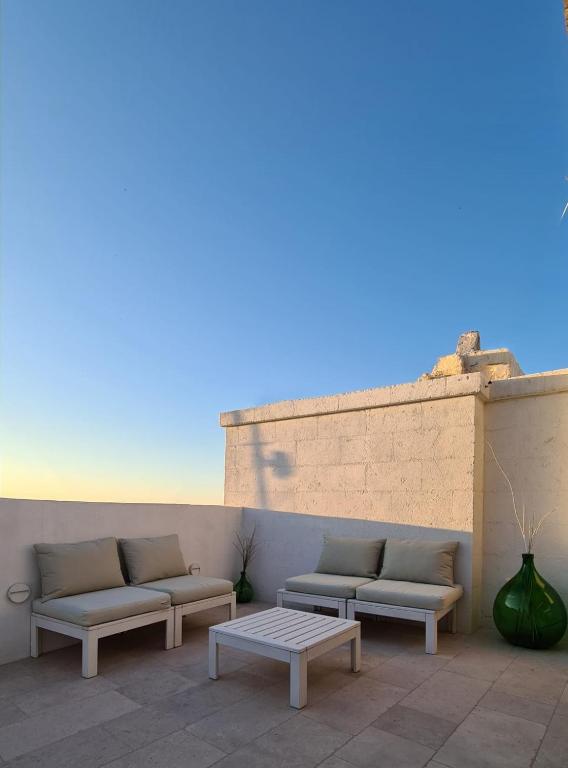 a patio with two couches and a coffee table at FONTEblu B&B in Polignano a Mare