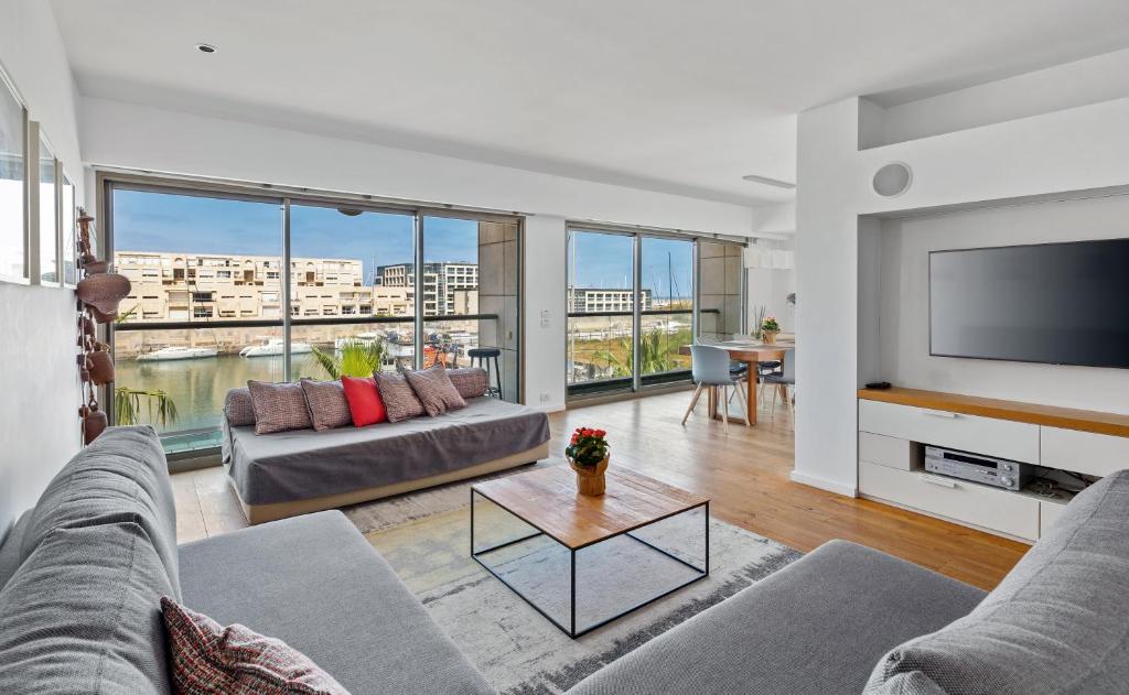 un soggiorno con divano e TV a schermo piatto di Lagoon View 3bd Huge Family Apartment a Herzelia
