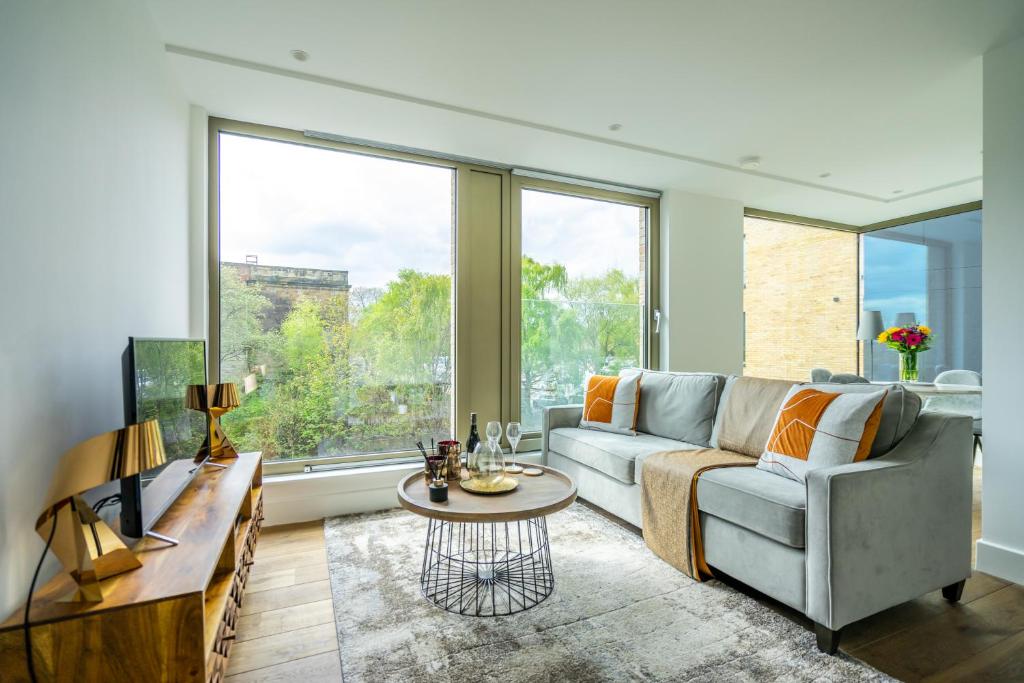 a living room with a couch and a large window at Waterfront @ Ryedale House in York