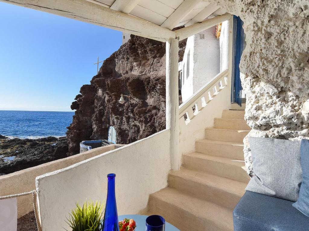 un escalier menant à un bâtiment avec vue sur l'océan dans l'établissement La Cueva de Caleta by VillaGranCanaria, à Gáldar