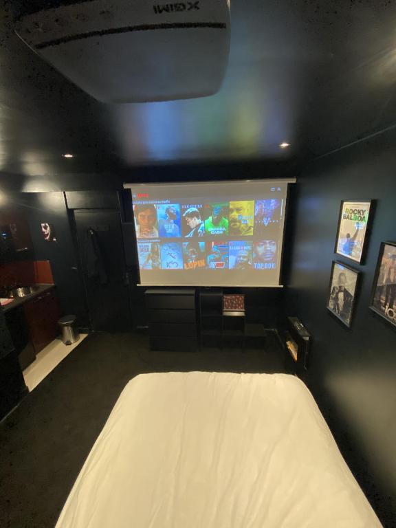 a room with a tv and a bed and a screen at Lh Rooms Location in Le Havre