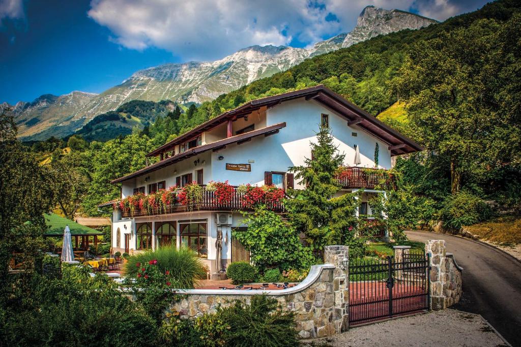 a house with flowers in front of a mountain at Tourist Farm Kranjc in Kobarid