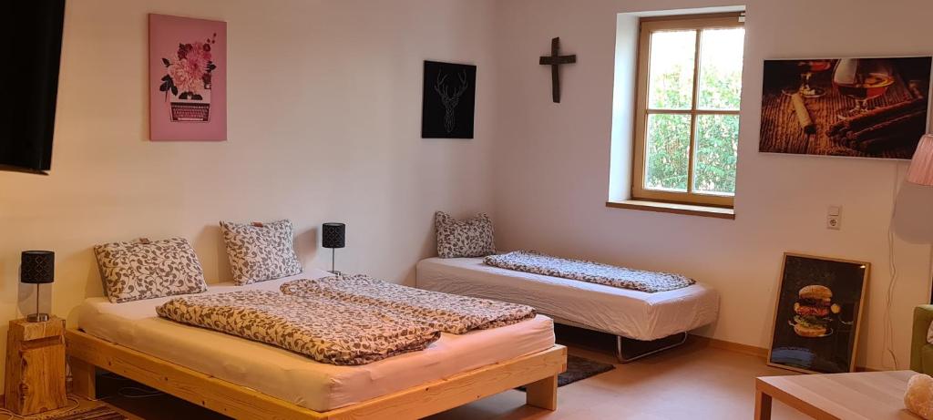 a room with two beds and a cross on the wall at Wolfis Appartement in Neusiedl an der Zaya