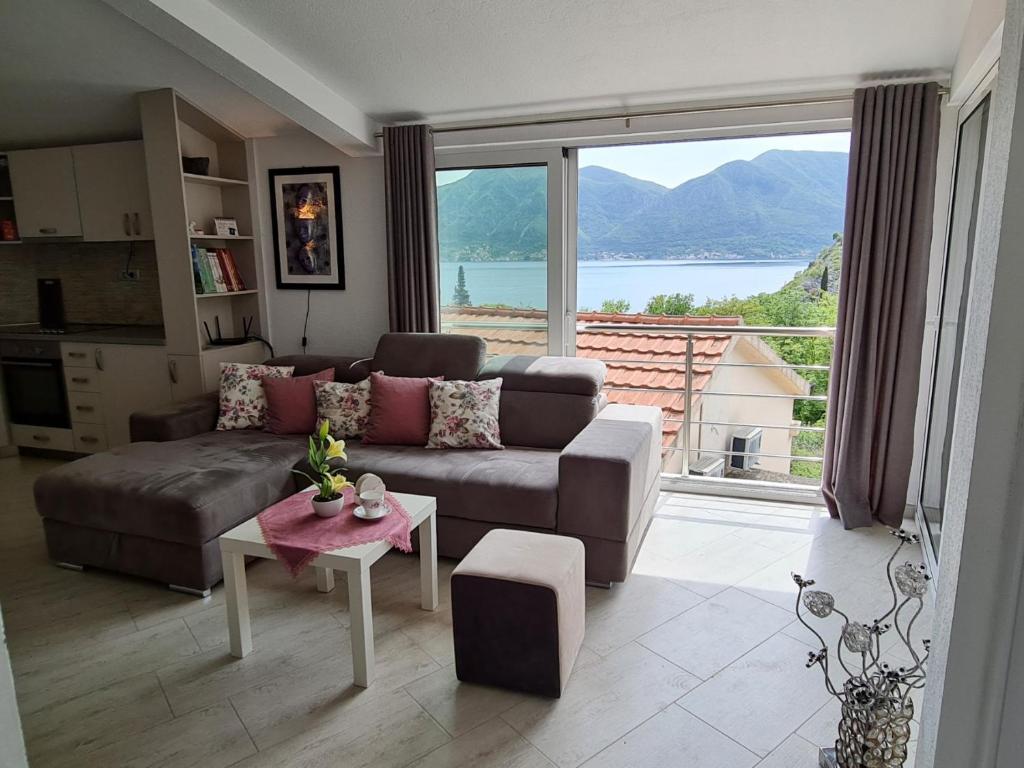 a living room with a couch and a large window at Lux apartmani Darija in Kotor