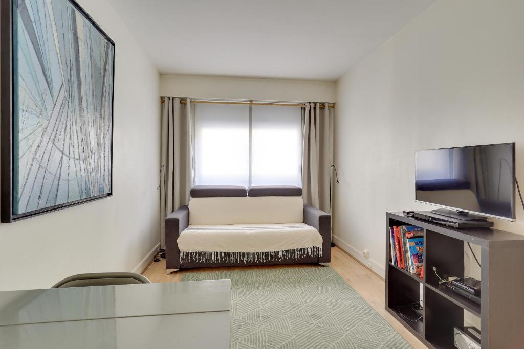 un salon avec un canapé et une télévision dans l'établissement ID 326 Batignolles/ rue Saussure - Paris XVII°, à Paris