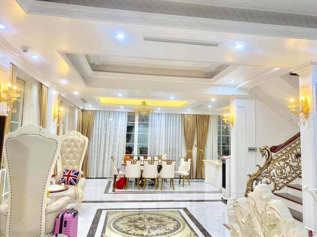 a dining room with white chairs and a table at Biệt Thự FLC Sầm Sơn 4-8 Phòng Ngủ in Binh Tân