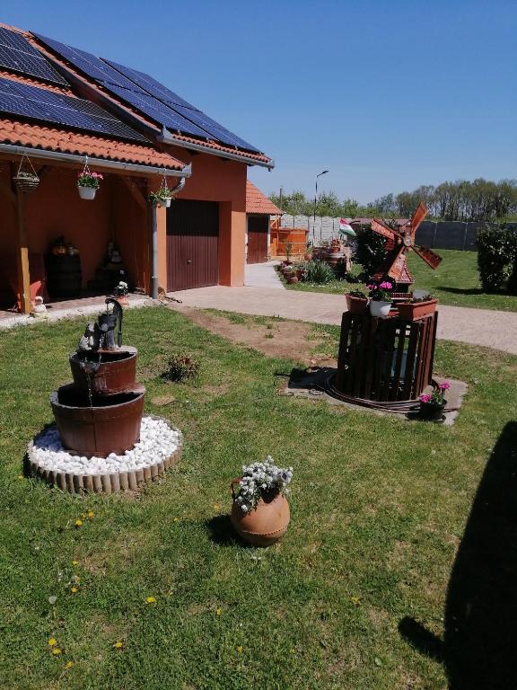 a yard with a statue in the grass at Zeg-zug Vendégház in Nemesdéd