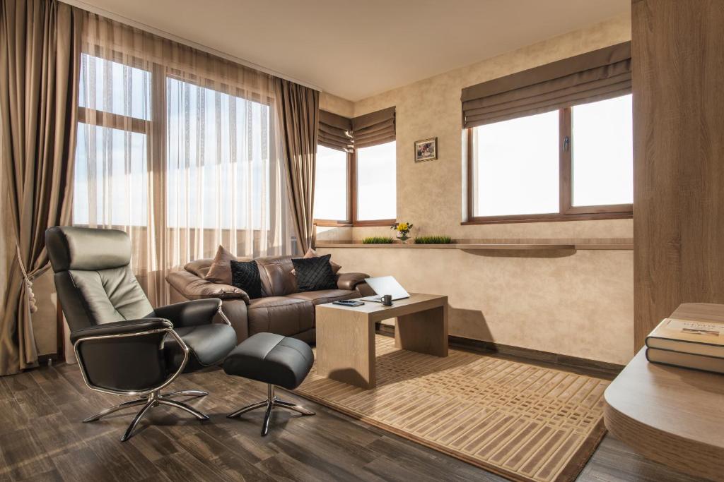 een woonkamer met een bank en een tafel en stoelen bij Boutique Apartments - Sevtopolis in Kazanlik