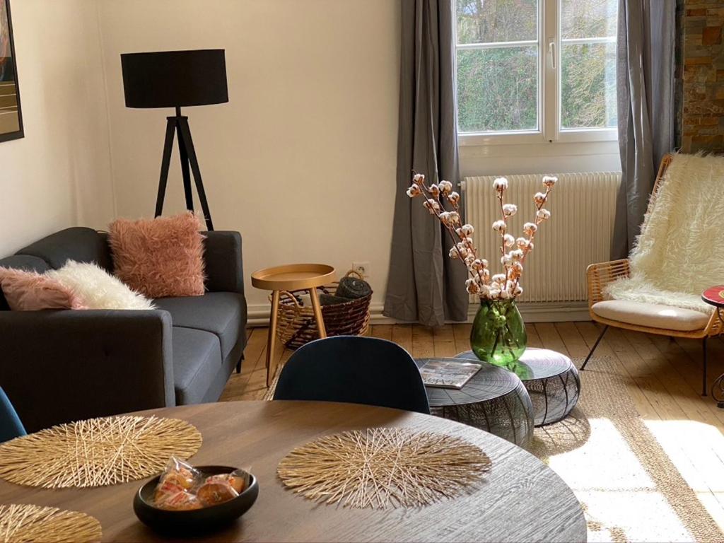 ein Wohnzimmer mit einem Tisch und Stühlen in der Unterkunft Quiétude en hyper-centre in Blois