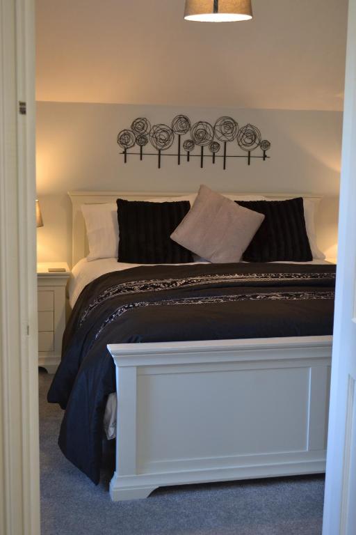 a bedroom with a bed with a black and white blanket at Coed-y-Fron in Betws-y-coed