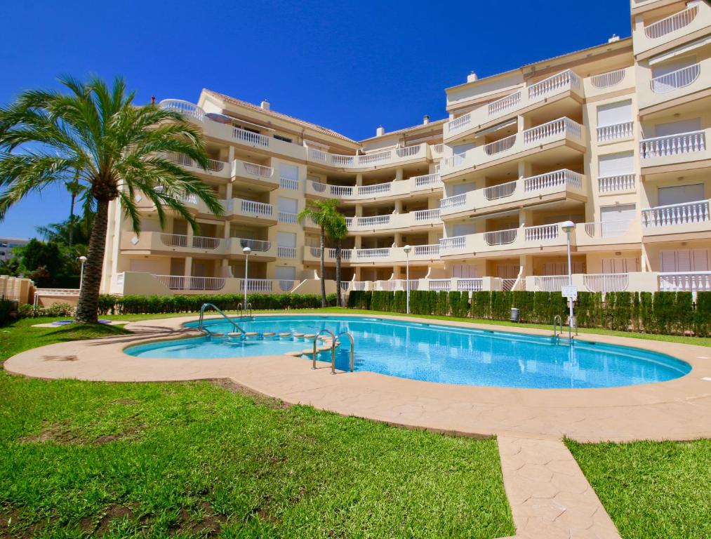 a swimming pool in front of a large apartment building at Residencial Playa Sol III in Denia