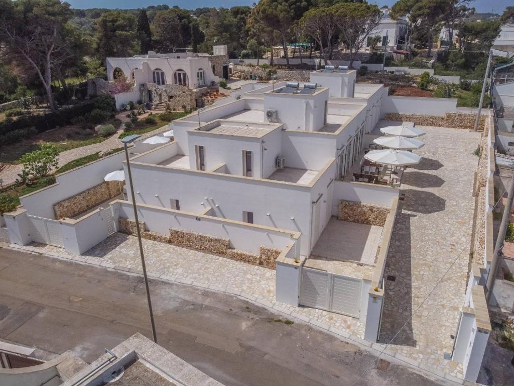 an aerial view of a white building with umbrellas at B&BLeucaineout in Leuca