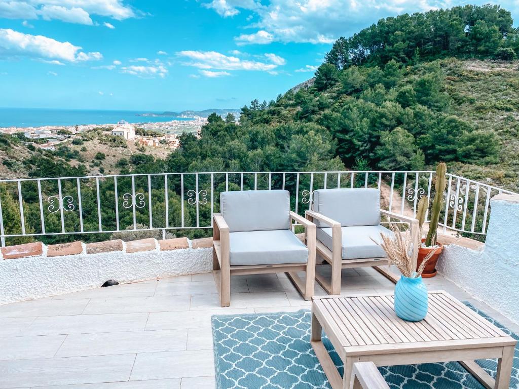 2 Stühle und ein Tisch auf einem Balkon mit Meerblick in der Unterkunft Montgo Home in Jávea