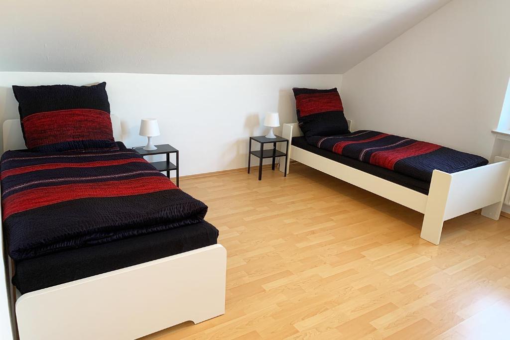 two beds in a room with wooden floors at Ruhig gelegene Ferienwohnung mit WLAN in Olpe