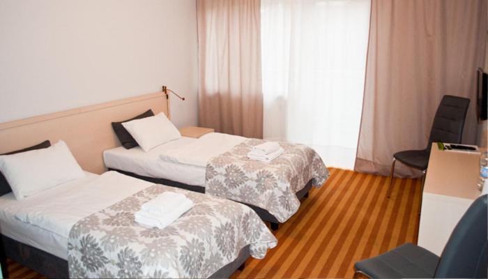 a hotel room with two beds and a window at Zdrojówka Noclegi in Kleosin