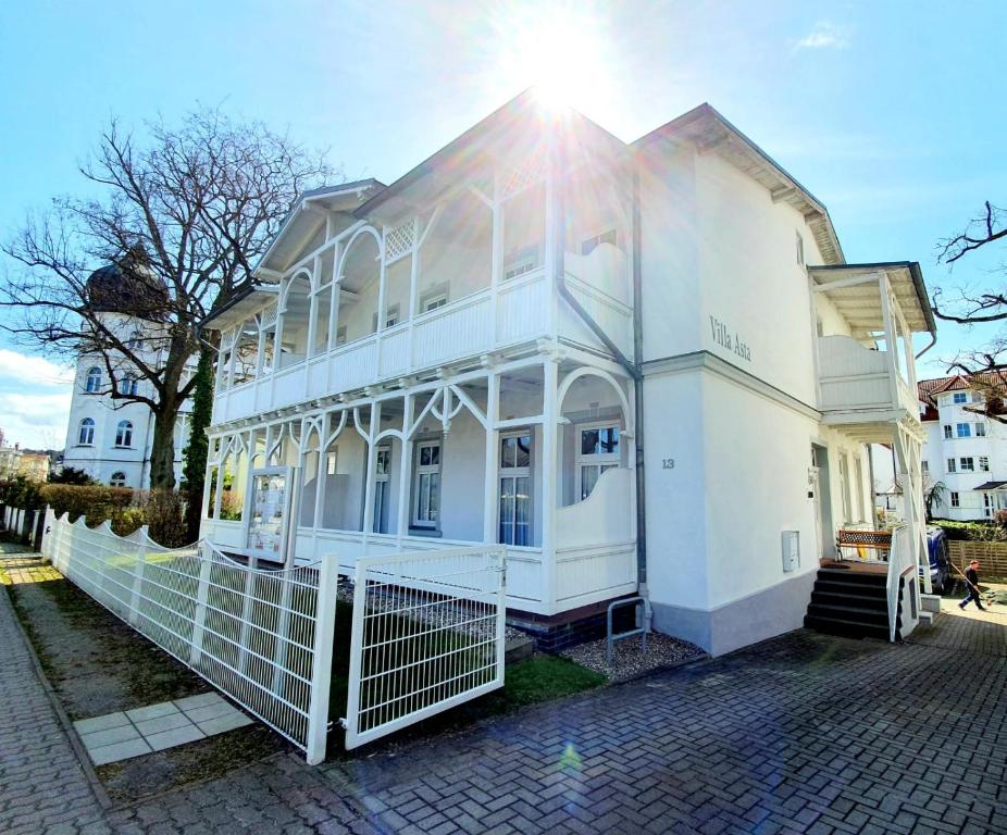 a white house with the sun shining on it at Villa Asta in Binz