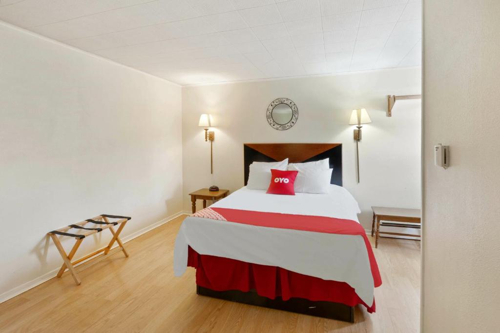 um quarto com uma cama grande e almofadas vermelhas em OYO Hotel Buena Vista Delhi em Delhi