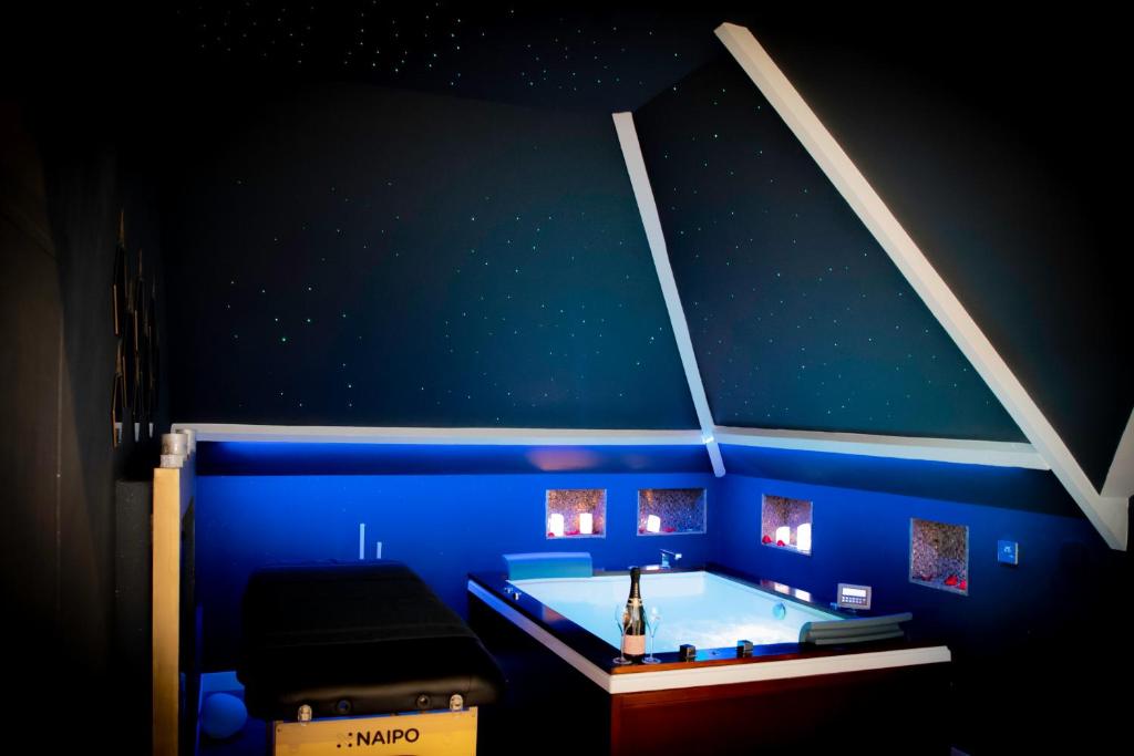 ein blaues Zimmer mit Badewanne in einem Zimmer mit Sternen in der Unterkunft Le Loft de Zoé in Saint-Sylvain