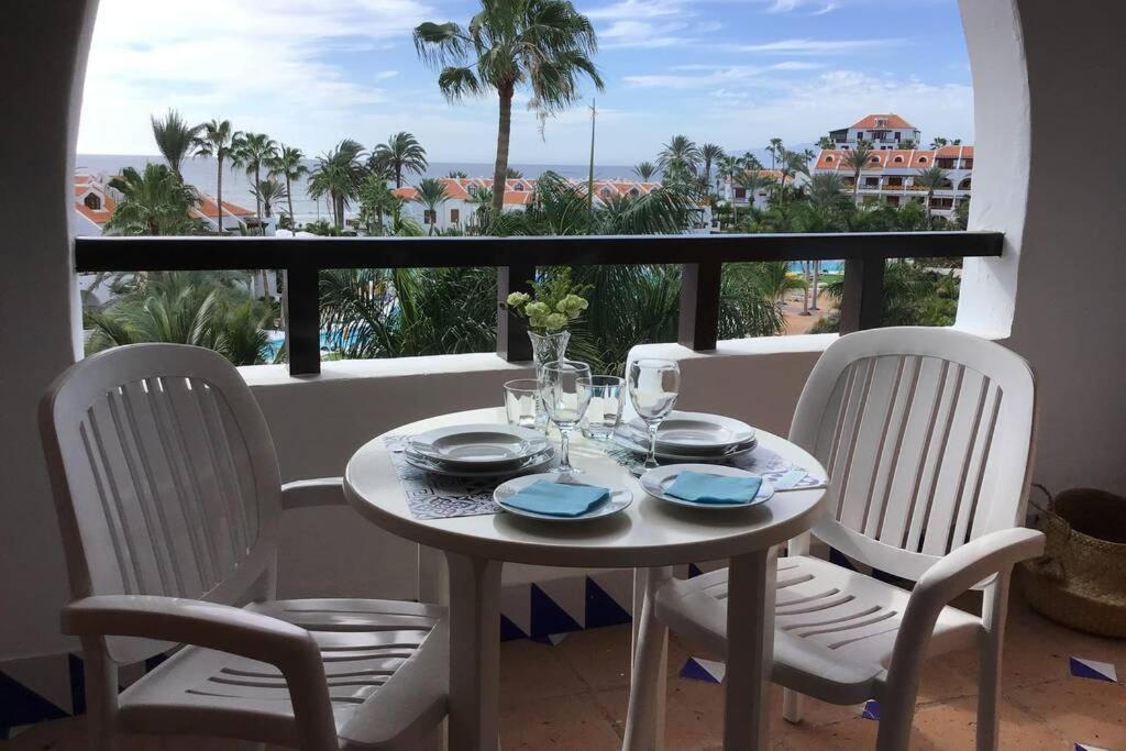a table and chairs on a balcony with a view of the ocean at Apartamento frente al mar! in Playa de las Americas