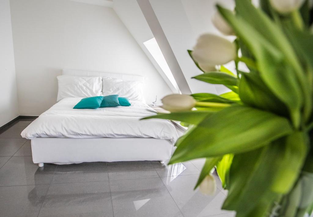 Un dormitorio con una cama blanca y una planta en Self Service Hotel Kernhof Langstrasse, en Zúrich