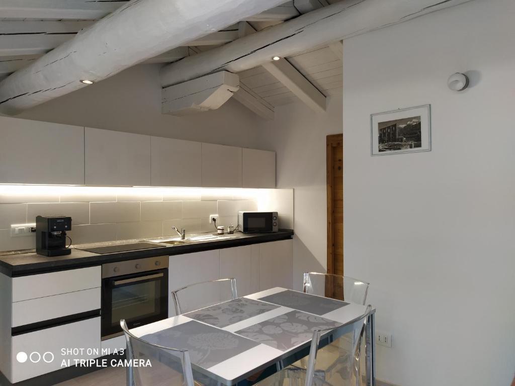Una cocina con una mesa y sillas en una habitación. en Un oeil sur la cathédrale, en Aosta