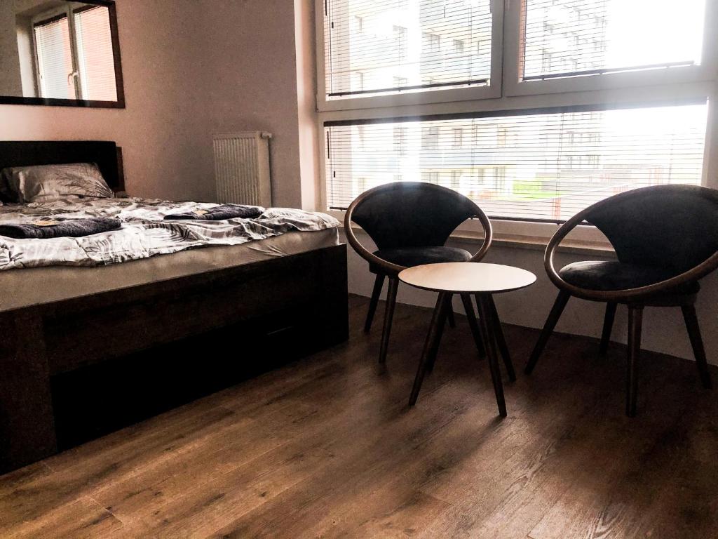 a bedroom with two chairs and a bed and a table at Apartament Bastion Wałowa Gdańsk in Gdańsk