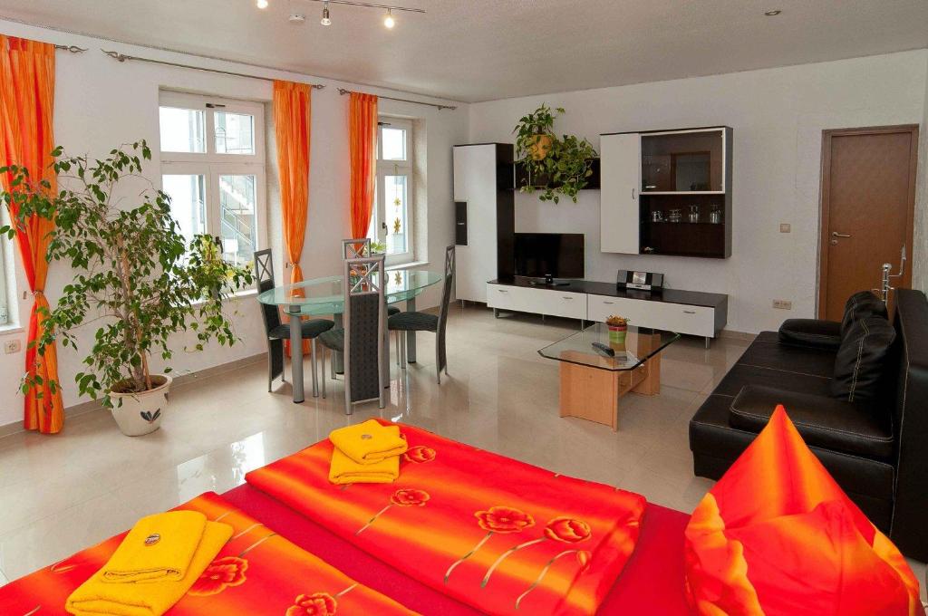 ein Wohnzimmer mit einem roten Bett und einem Wohnzimmer in der Unterkunft Hotel Am Müritzhafen garni in Waren (Müritz)