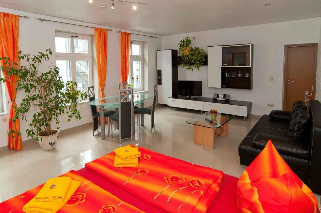 a living room with a red bed and a living room at Hotel Am Müritzhafen garni in Waren