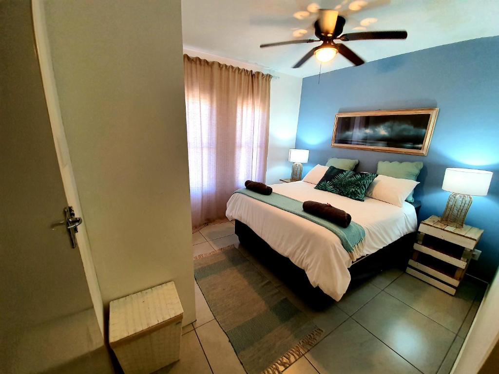 - une chambre avec un lit et un ventilateur de plafond dans l'établissement South seas safari @ The Bridge apartments, à St Lucia