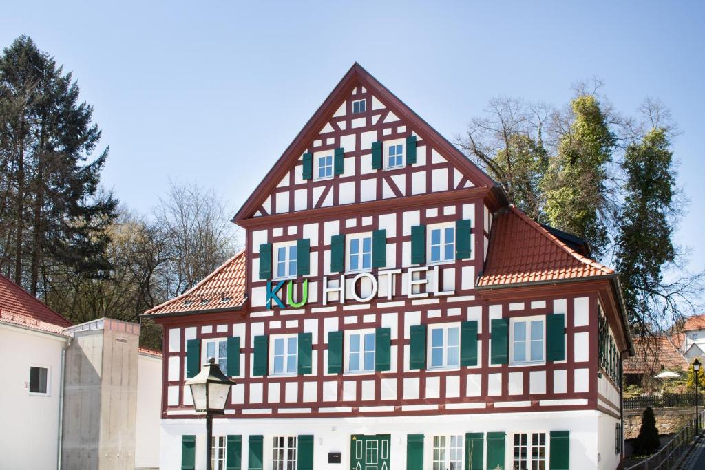 un edificio con entramado de madera con un cartel. en KU Hotel by WMM Hotels, en Kulmbach