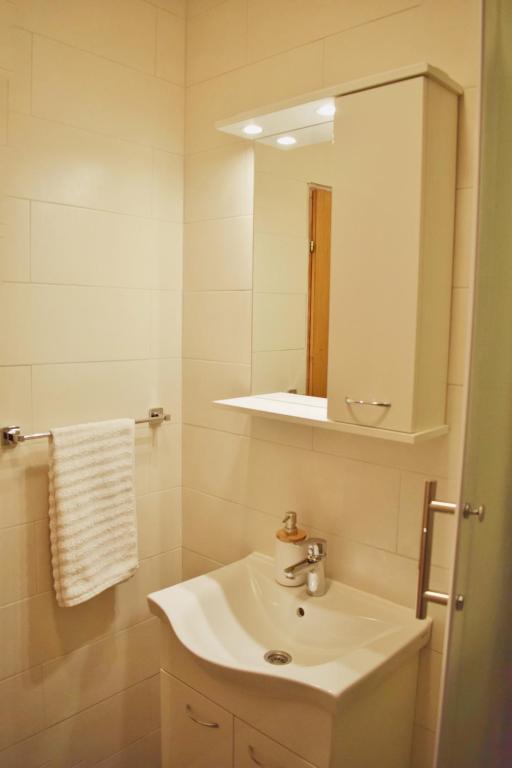 La salle de bains blanche est pourvue d'un lavabo et d'un miroir. dans l'établissement Mljet Sunset Apartments, à Pomena