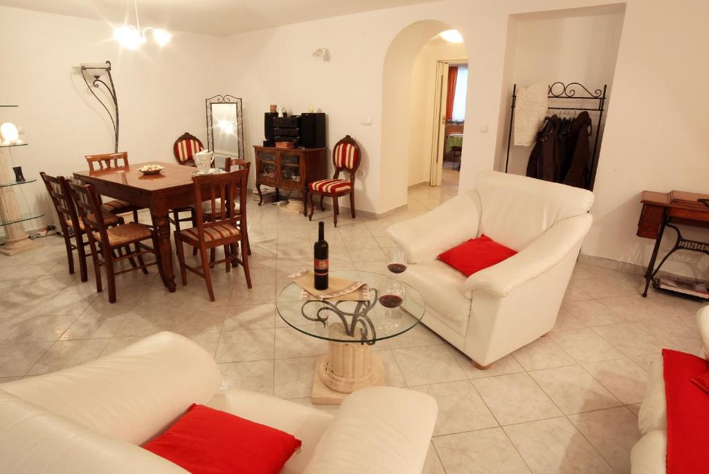 sala de estar con muebles blancos y comedor en Apartment Antique Forum, en Pula