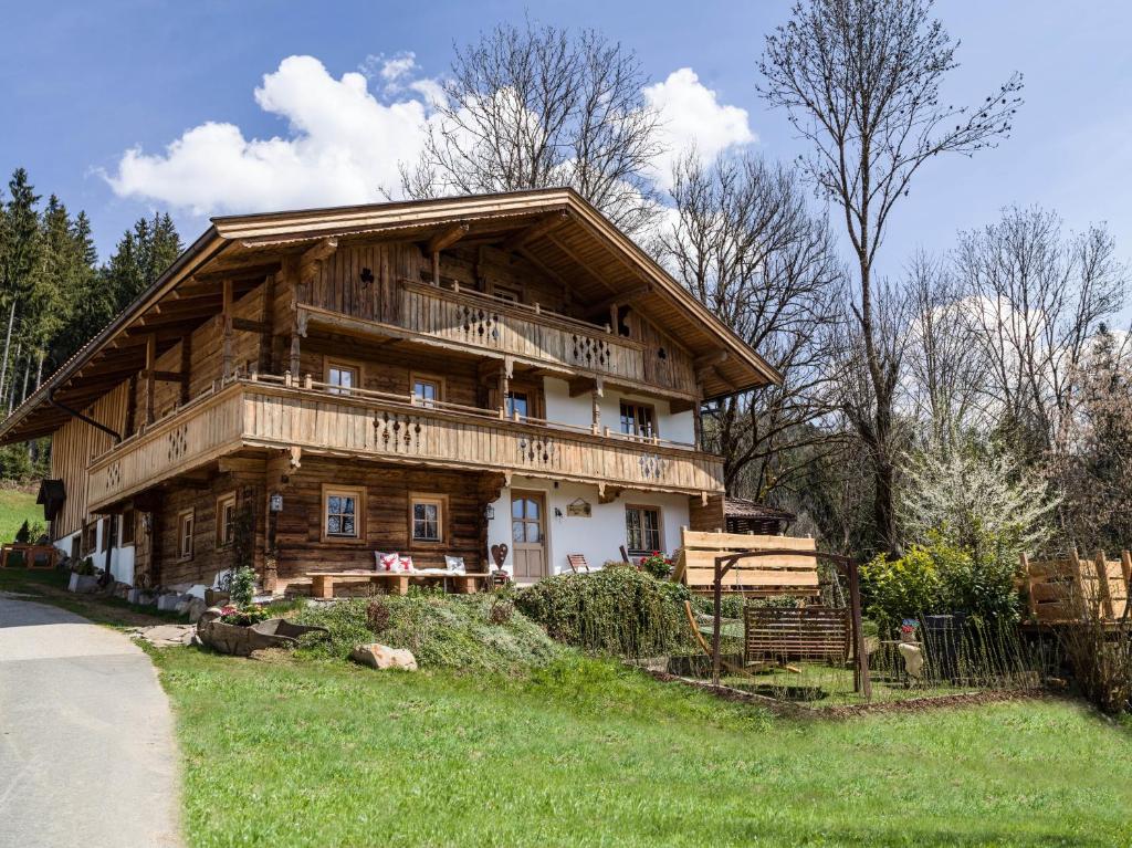 a large wooden house sitting on top of a lush green field at Schneiderhof in Itter